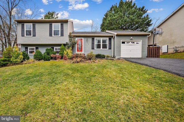 tri-level home featuring a garage and a front lawn