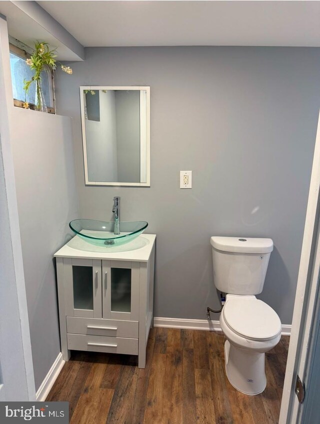 bathroom featuring wood-type flooring, toilet, and vanity