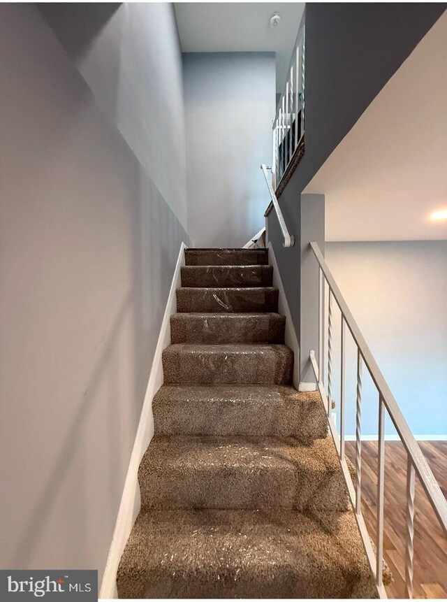 staircase with wood-type flooring