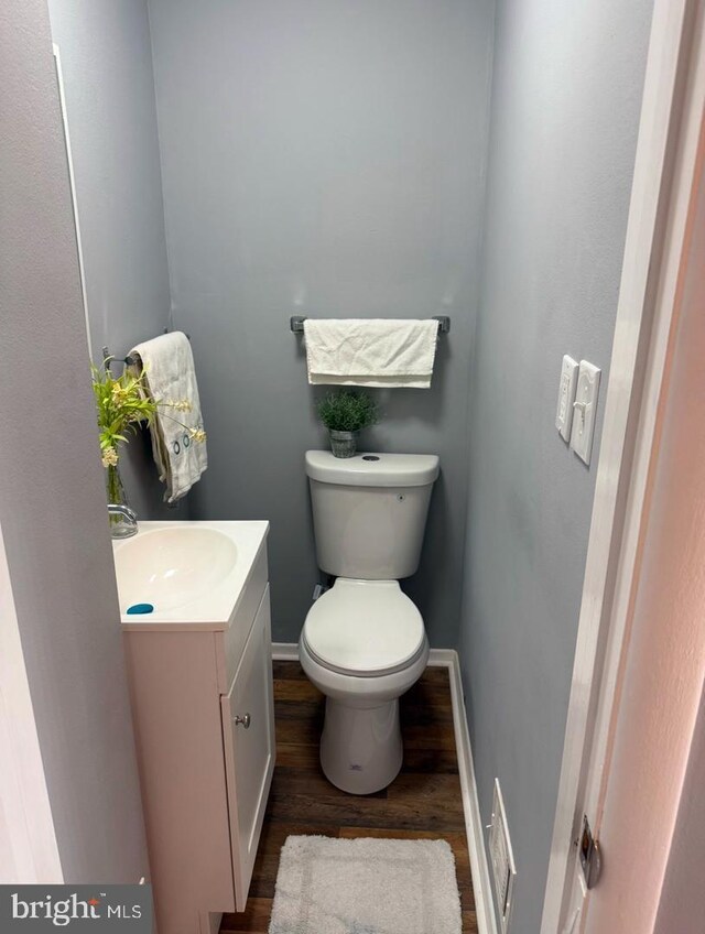 bathroom with vanity, toilet, and wood-type flooring