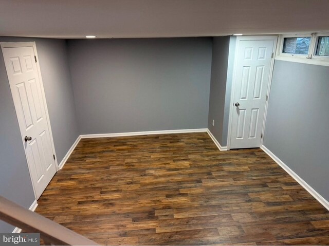 basement with dark hardwood / wood-style floors