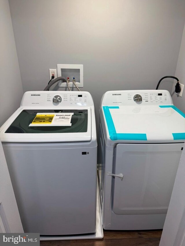 laundry room featuring washer and dryer and dark hardwood / wood-style floors