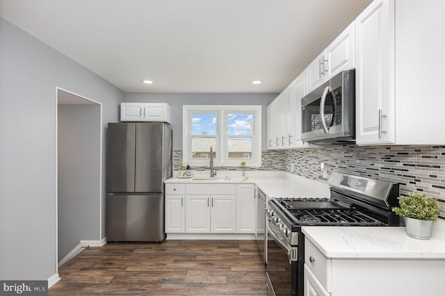 kitchen featuring stainless steel appliances, sink, white cabinets, and dark hardwood / wood-style floors