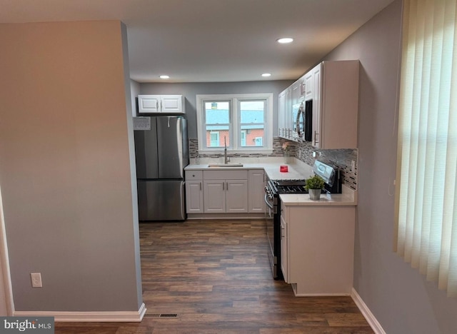 kitchen featuring sink, dark wood-type flooring, white cabinets, and appliances with stainless steel finishes