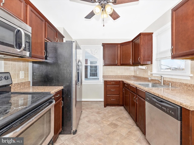 kitchen featuring tasteful backsplash, appliances with stainless steel finishes, sink, and ceiling fan