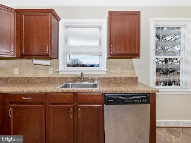 kitchen featuring dishwasher, sink, and backsplash