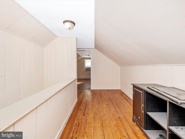 additional living space featuring lofted ceiling and light wood-type flooring