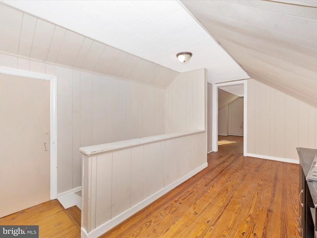 additional living space with lofted ceiling and hardwood / wood-style floors