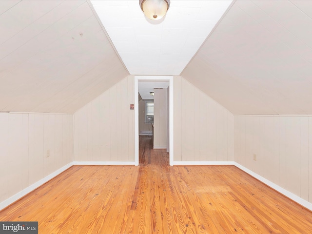 additional living space with lofted ceiling and light hardwood / wood-style flooring