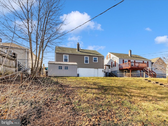 back of property with a wooden deck and a yard