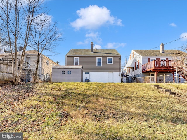 back of house featuring a wooden deck and a yard