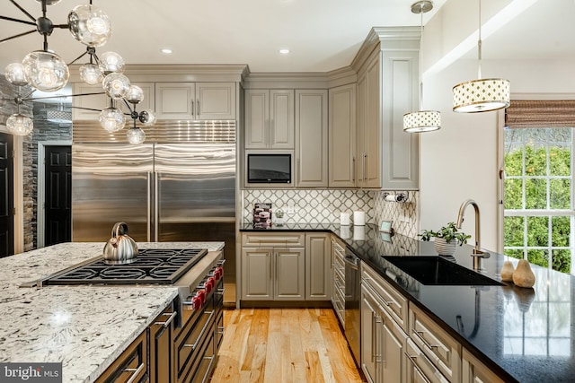 19 Longwood Ln, Newark, DE 19711 - kitchen featuring a sink, light wood-style floors, built in appliances, dark stone counters, and decorative backsplash