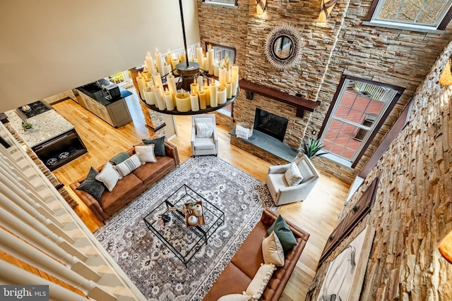 19 Longwood Ln, Newark, DE 19711 - living room featuring a chandelier, a stone fireplace, wood finished floors, and plenty of natural light
