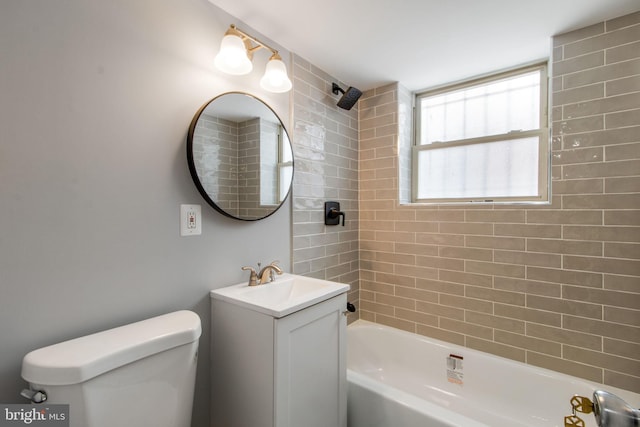 full bathroom featuring vanity, tiled shower / bath combo, and toilet