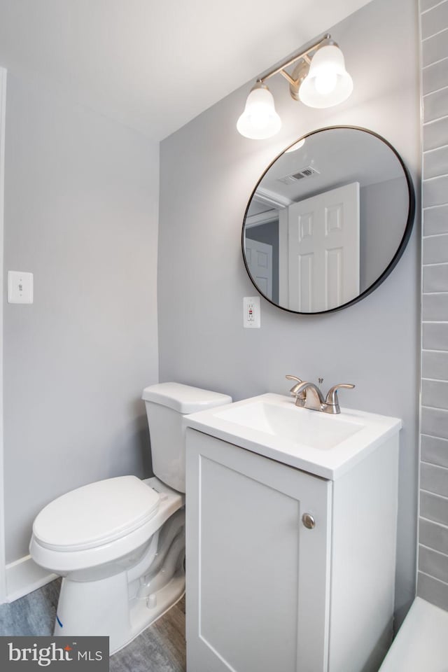 bathroom featuring vanity, toilet, and wood-type flooring