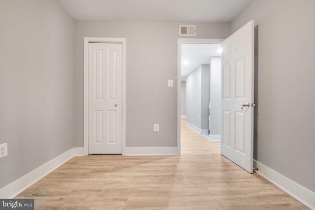 unfurnished bedroom with light hardwood / wood-style floors and a closet