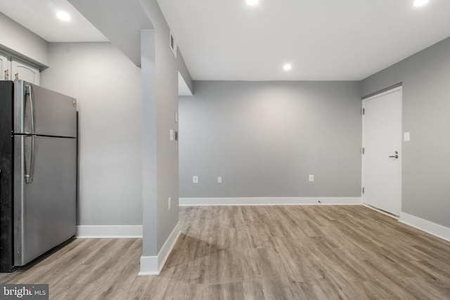 kitchen with white cabinetry, stainless steel fridge, and light hardwood / wood-style floors