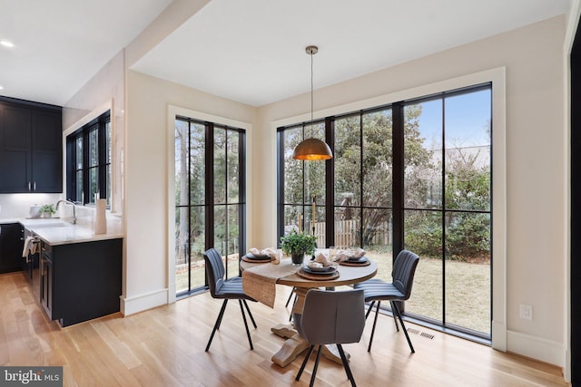 dining room with light wood-type flooring, baseboards, and visible vents