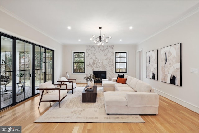 living room with a high end fireplace, crown molding, light wood-style flooring, and baseboards