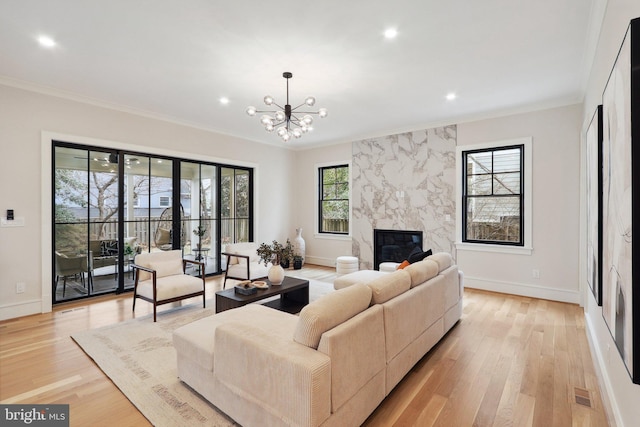 living room with light wood finished floors, visible vents, ornamental molding, and a high end fireplace