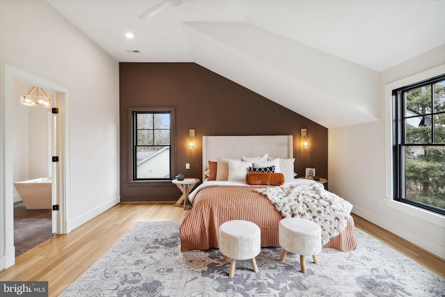 bedroom with lofted ceiling, light wood-style floors, multiple windows, and baseboards