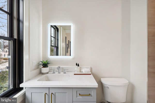 half bathroom with vanity and toilet