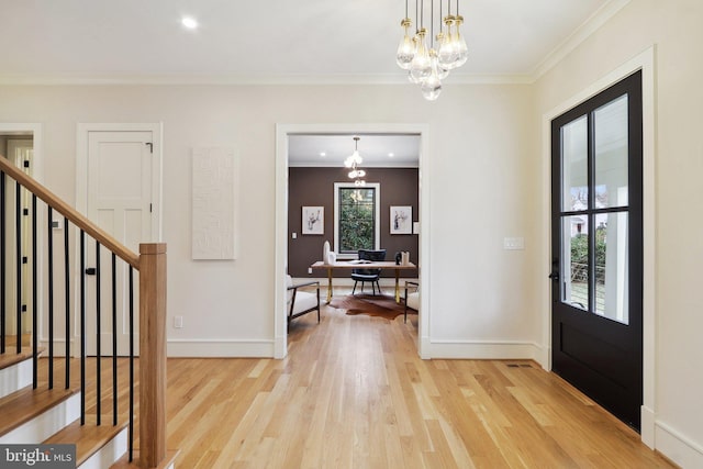 foyer entrance featuring crown molding, a notable chandelier, and light wood finished floors