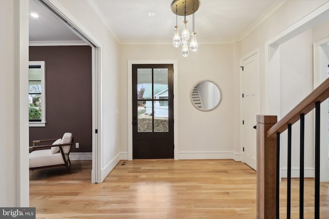 foyer with baseboards, light wood-style flooring, stairs, crown molding, and a chandelier