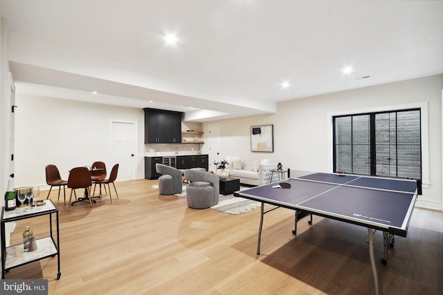 game room with recessed lighting, bar area, and wood finished floors