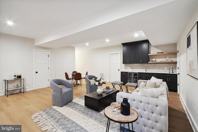 living room with wine cooler, light wood finished floors, recessed lighting, visible vents, and wet bar