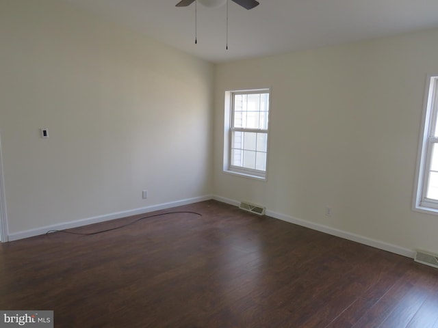 spare room featuring dark wood-type flooring and ceiling fan