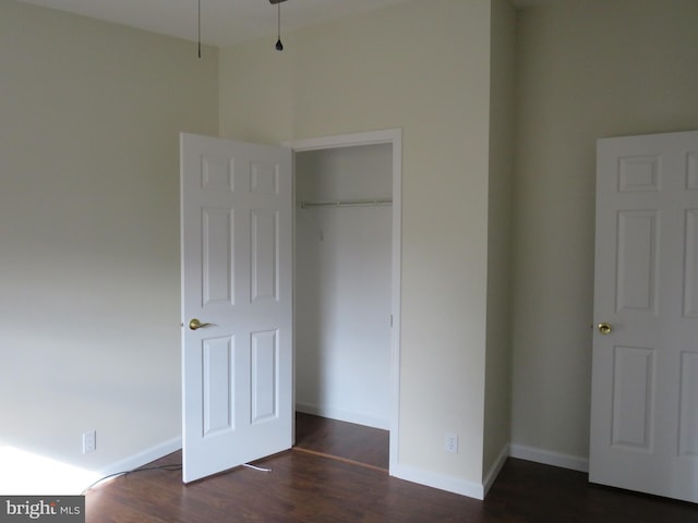 unfurnished bedroom featuring dark hardwood / wood-style flooring and a closet