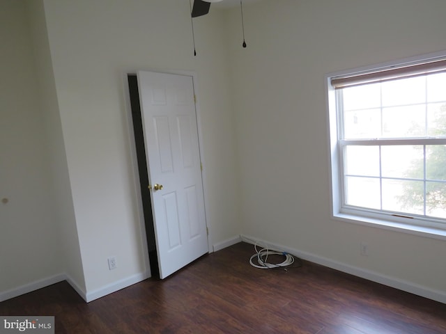 empty room with dark hardwood / wood-style floors and ceiling fan