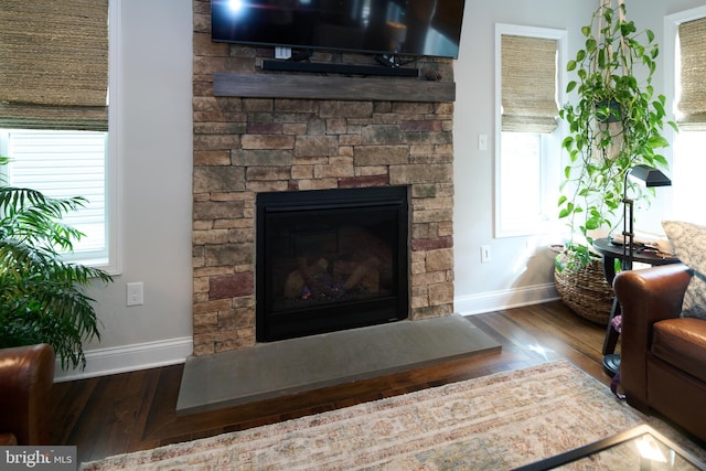 living room with dark wood-type flooring and a fireplace