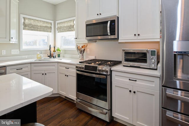 kitchen featuring white cabinetry, appliances with stainless steel finishes, dark hardwood / wood-style flooring, and sink