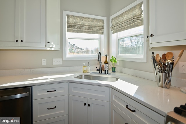 kitchen featuring white cabinetry, dishwasher, and sink