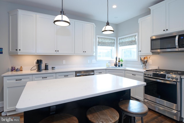 kitchen with white cabinetry, appliances with stainless steel finishes, a center island, and pendant lighting