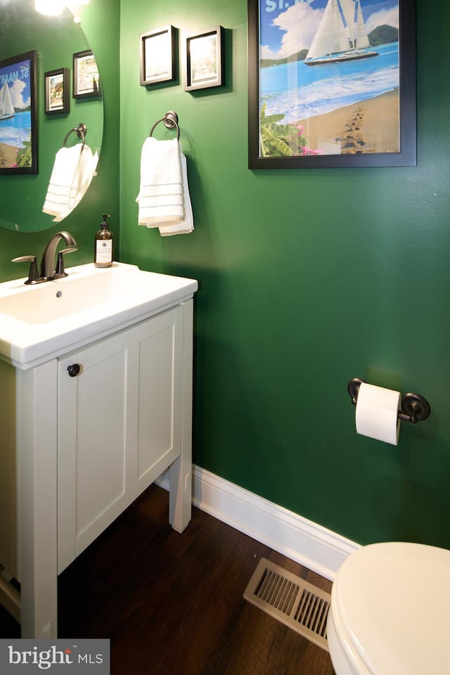 bathroom featuring vanity, toilet, and hardwood / wood-style floors