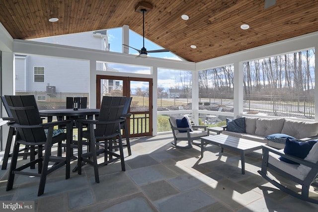 sunroom / solarium with wood ceiling, ceiling fan, and vaulted ceiling