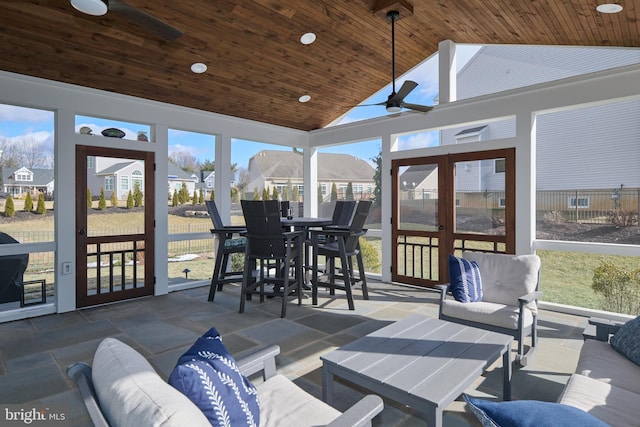 sunroom featuring lofted ceiling, wooden ceiling, and ceiling fan