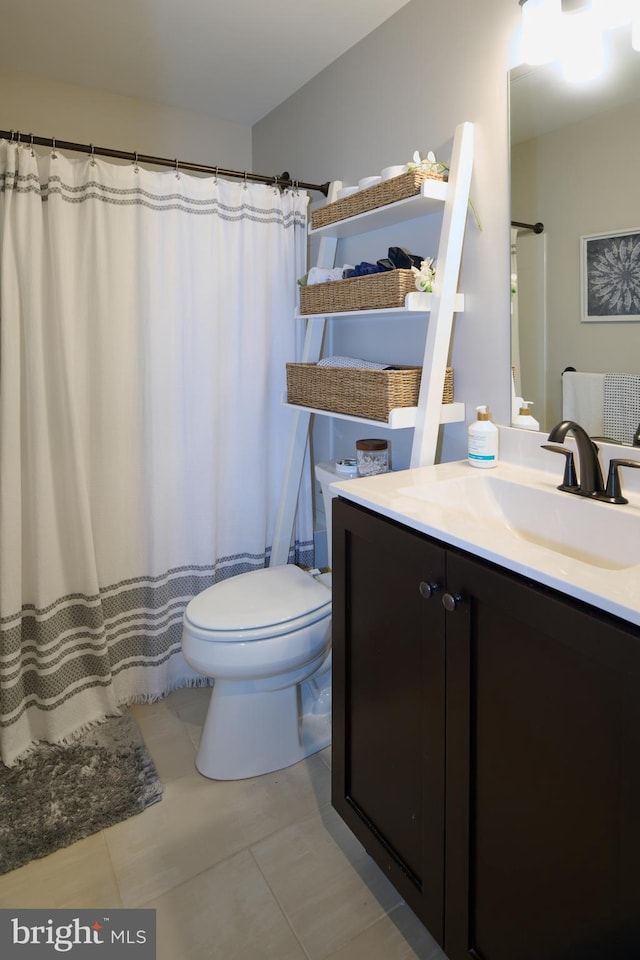 bathroom featuring vanity, tile patterned flooring, and toilet