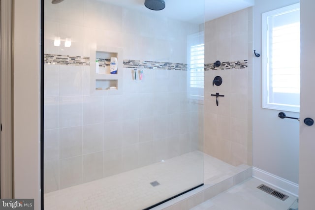 bathroom featuring tiled shower and a healthy amount of sunlight