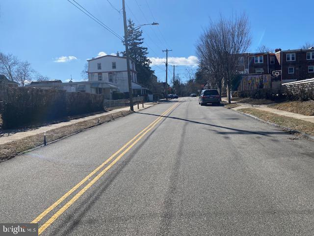 view of road with curbs, street lighting, sidewalks, and a residential view