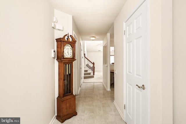 hall featuring stairs and baseboards