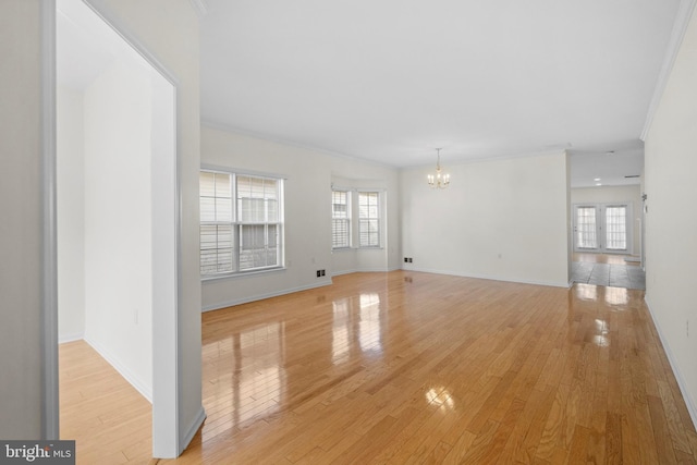 unfurnished living room with plenty of natural light, light hardwood / wood-style floors, and a chandelier