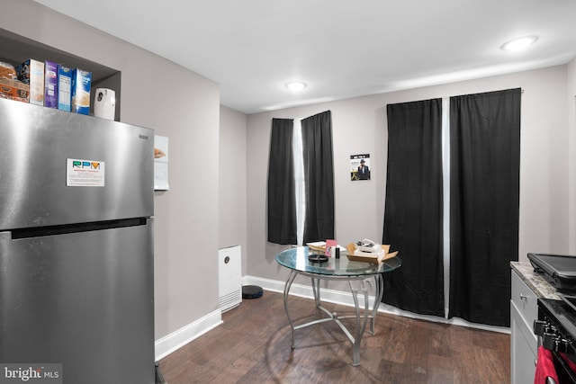 kitchen with dark hardwood / wood-style flooring and stainless steel refrigerator