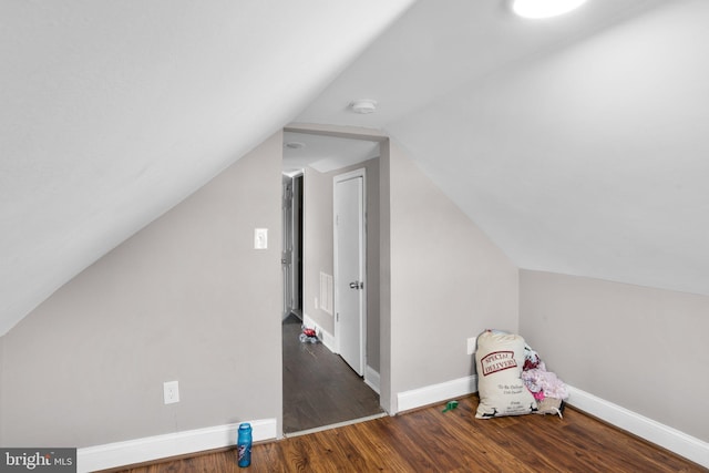 bonus room with dark wood-type flooring and lofted ceiling