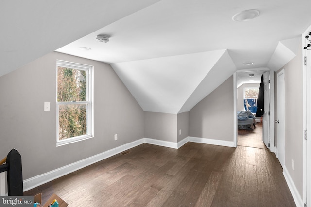 additional living space featuring lofted ceiling and dark wood-type flooring