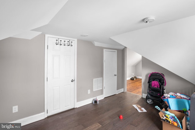 bonus room with lofted ceiling and dark hardwood / wood-style floors