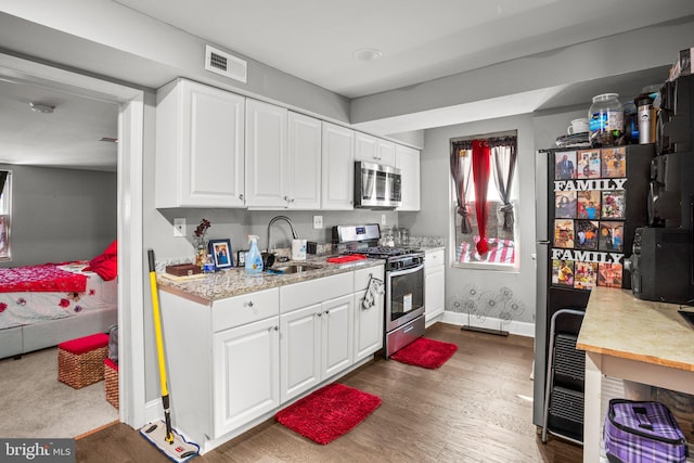 kitchen featuring white cabinetry, sink, dark wood-type flooring, and appliances with stainless steel finishes